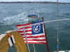 30-dinghybehindflag.JPG (160350 bytes)